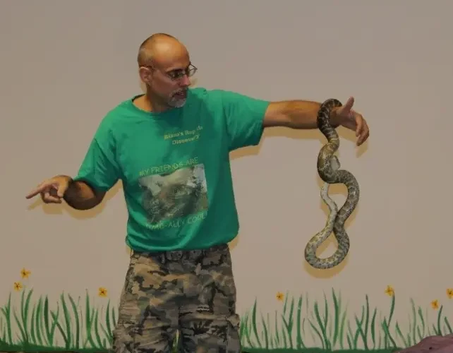 Wildlife educator holding out a Burmese python