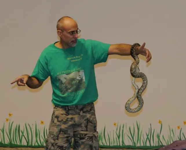 Wildlife educator holding out a Burmese python
